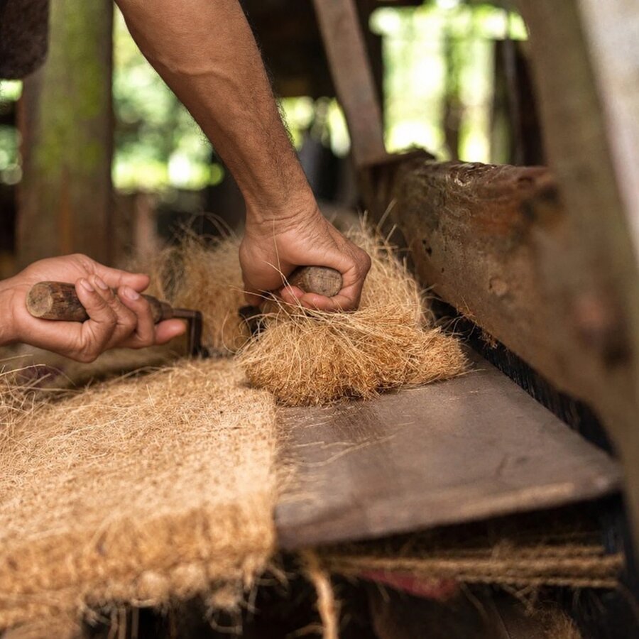 Coir fibre being processed by hand on a traditional loom